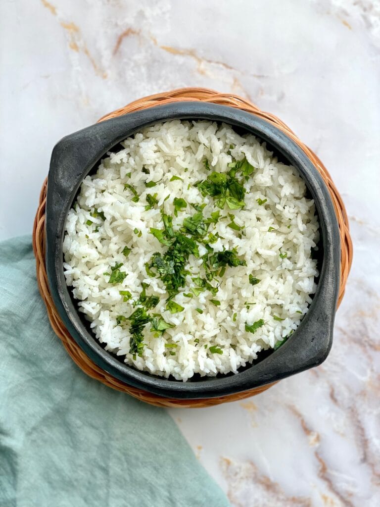white rice served in a traditional colombian bowl topped with cilantro.