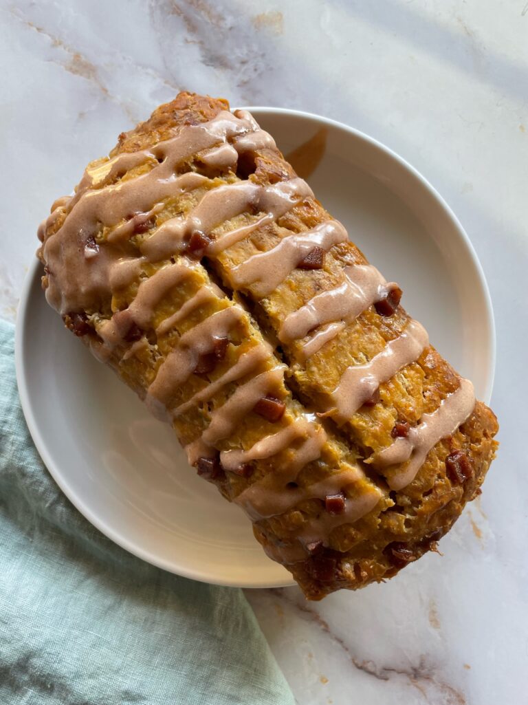 platano bread on a white circle plate with a guava glaze drizzled on top